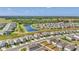 An aerial view displays houses in a community bordering a peaceful lake and green spaces at 13013 Oak Hill Way, Parrish, FL 34219