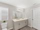 Bright bathroom features a double vanity, neutral tones, and wood-look flooring at 13013 Oak Hill Way, Parrish, FL 34219
