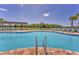 Modern community pool featuring a zero entry point, lounge chairs, and lake views at 13013 Oak Hill Way, Parrish, FL 34219