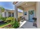 A covered porch with a bench, potted flowers, and a decorated front door welcomes visitors at 13013 Oak Hill Way, Parrish, FL 34219