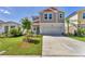 Well-maintained lawn with landscaped flowerbeds in front of a neutral, two-story home with an attached garage at 13013 Oak Hill Way, Parrish, FL 34219