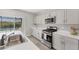 Modern kitchen with gray cabinets, stainless appliances, and a view of the screened in pool at 13013 Oak Hill Way, Parrish, FL 34219