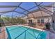 A screened-in pool offers a relaxing backyard and an outdoor dining table with seating at 13013 Oak Hill Way, Parrish, FL 34219
