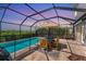 Relax by the sparkling pool in the screened enclosure, complete with dining area and lush greenery at 13013 Oak Hill Way, Parrish, FL 34219