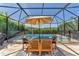A screened-in pool features an outdoor dining table with seating and lots of room at 13013 Oak Hill Way, Parrish, FL 34219