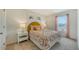 Well-lit bedroom featuring a floral-patterned bed, playful artwork, and a pleasant view from the window at 13124 Bayberry Way, Parrish, FL 34219