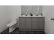 Modern bathroom featuring double vanity sinks, neutral tones, and a toilet at 13128 Bayberry Way, Parrish, FL 34219