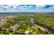 Beautiful aerial view of the property highlighting a lake and lush green surroundings on a bright, sunny day at 14921 Barrows Bluff Ter, Bradenton, FL 34212