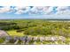 An aerial view shows the house surrounded by lush greenery and ponds, providing a sense of privacy at 14921 Barrows Bluff Ter, Bradenton, FL 34212
