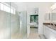 Modern bathroom with glass-enclosed shower and views into the main bedroom at 14921 Barrows Bluff Ter, Bradenton, FL 34212