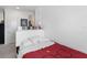 Bedroom with white headboard, bright red comforter, and a view of an open door at 14921 Barrows Bluff Ter, Bradenton, FL 34212