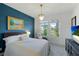 Bright bedroom with white bedding, a blue accent wall, and a crystal chandelier at 14921 Barrows Bluff Ter, Bradenton, FL 34212