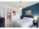 A bedroom shows off the blue accent wall, the crystal chandelier, and bathroom at 14921 Barrows Bluff Ter, Bradenton, FL 34212