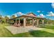 Community pavilion with multiple picnic tables, seating, and a brick patio for outdoor dining and community events at 14921 Barrows Bluff Ter, Bradenton, FL 34212