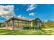 Community pavilion featuring picnic tables, ceiling fans, and a well-manicured lawn, perfect for outdoor gatherings and relaxation at 14921 Barrows Bluff Ter, Bradenton, FL 34212