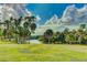 Scenic water view with lush landscaping, benches, and towering palm trees creates a peaceful outdoor retreat at 14921 Barrows Bluff Ter, Bradenton, FL 34212