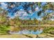 Beautiful pond reflecting the sky, surrounded by lush greenery and mature trees at 14921 Barrows Bluff Ter, Bradenton, FL 34212