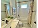 Bathroom with tub and shower combo, white tiling, shower curtain and modern fixtures at 16905 Sweetwater Village Dr, Bradenton, FL 34211