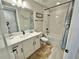 Bright bathroom features a white vanity with black fixtures, a framed mirror, and a tub with a shower at 16905 Sweetwater Village Dr, Bradenton, FL 34211