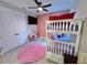 Charming bedroom featuring a bunk bed, pink rug, ceiling fan, and decorative pillows, perfect for a room at 16905 Sweetwater Village Dr, Bradenton, FL 34211