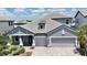 Beautiful single-Gathering home with a gray roof and three-car garage on a sunny day at 16905 Sweetwater Village Dr, Bradenton, FL 34211