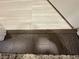 Close-up of mixed flooring: light tile and dark wood, meeting a plush carpet at 16905 Sweetwater Village Dr, Bradenton, FL 34211