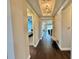 Inviting hallway with hardwood floors, decorative lighting, and views into adjacent rooms at 16905 Sweetwater Village Dr, Bradenton, FL 34211