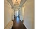Entry hallway featuring dark wood flooring, neutral walls, and an elegant light fixture at 16905 Sweetwater Village Dr, Bradenton, FL 34211