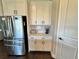 Kitchenette area, featuring a stainless refrigerator, white cabinets, and hardwood floors at 16905 Sweetwater Village Dr, Bradenton, FL 34211