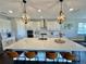 Modern kitchen featuring a large island with seating, pendant lighting, and white cabinets at 16905 Sweetwater Village Dr, Bradenton, FL 34211