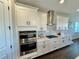 Modern kitchen featuring white cabinets, stainless steel appliances, and hard wood floors at 16905 Sweetwater Village Dr, Bradenton, FL 34211