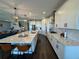Open kitchen with a large marble island, hardwood floors, and white cabinetry at 16905 Sweetwater Village Dr, Bradenton, FL 34211