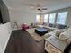 Bright living room with a large sectional sofa and ample natural light from large windows at 16905 Sweetwater Village Dr, Bradenton, FL 34211