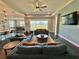 Spacious living room with stylish sofas, a modern fan, decorative wall, and pond view at 16905 Sweetwater Village Dr, Bradenton, FL 34211