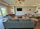 Spacious living room showcases stylish sofas, tray ceiling, modern fan, and a decorative wall at 16905 Sweetwater Village Dr, Bradenton, FL 34211