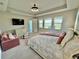 Large main bedroom suite with tray ceiling, carpet and views of the pond at 16905 Sweetwater Village Dr, Bradenton, FL 34211