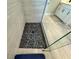 Walk-in shower features a black pebble floor and light, neutral colored tile walls at 16905 Sweetwater Village Dr, Bradenton, FL 34211