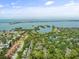 Aerial view showcasing waterfront condos surrounded by lush trees and bay views at 1703 Pelican Cove Rd # 356, Sarasota, FL 34231