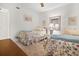 Bright bedroom featuring two twin beds with floral bedding and a ceiling fan at 1703 Pelican Cove Rd # 356, Sarasota, FL 34231