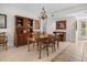 Dining room featuring a dark wood table and chairs, hutch, chandelier, tile flooring, and natural light at 1703 Pelican Cove Rd # 356, Sarasota, FL 34231
