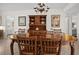 Elegant dining room with a dark wood table, chairs, and hutch, complemented by tile floors and decorative lighting at 1703 Pelican Cove Rd # 356, Sarasota, FL 34231