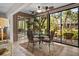 Bright dining area with glass walls, ceiling fans and stylish furniture, next to a garden view at 1703 Pelican Cove Rd # 356, Sarasota, FL 34231