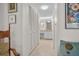 Hallway view of a bedroom, with white walls, wardrobe, decorative mirror, and a partial view of the bathroom at 1703 Pelican Cove Rd # 356, Sarasota, FL 34231