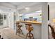 Cozy kitchen bar area with bright decor, stylish barstools, and a view of the shutters at 1703 Pelican Cove Rd # 356, Sarasota, FL 34231