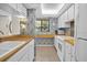 Bright kitchen with wood countertops, white appliances, and floral patterned wallpaper, creating a unique space at 1703 Pelican Cove Rd # 356, Sarasota, FL 34231