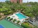 Aerial view of community pool and jacuzzi surrounded by lounge chairs and greenery at 1703 Pelican Cove Rd # 356, Sarasota, FL 34231