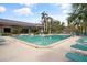 Community pool with solar panels, lounge chairs and lush landscaping, ideal for relaxation at 1703 Pelican Cove Rd # 356, Sarasota, FL 34231