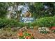 Inviting 'Pelican Cove' sign surrounded by colorful flowers and greenery for a warm welcome at 1703 Pelican Cove Rd # 356, Sarasota, FL 34231