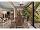 Bright sunroom with four chairs, ceiling fan and a view to the backyard at 1703 Pelican Cove Rd # 356, Sarasota, FL 34231