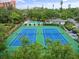 Aerial view of community tennis courts with pool in the background at 1703 Pelican Cove Rd # 356, Sarasota, FL 34231